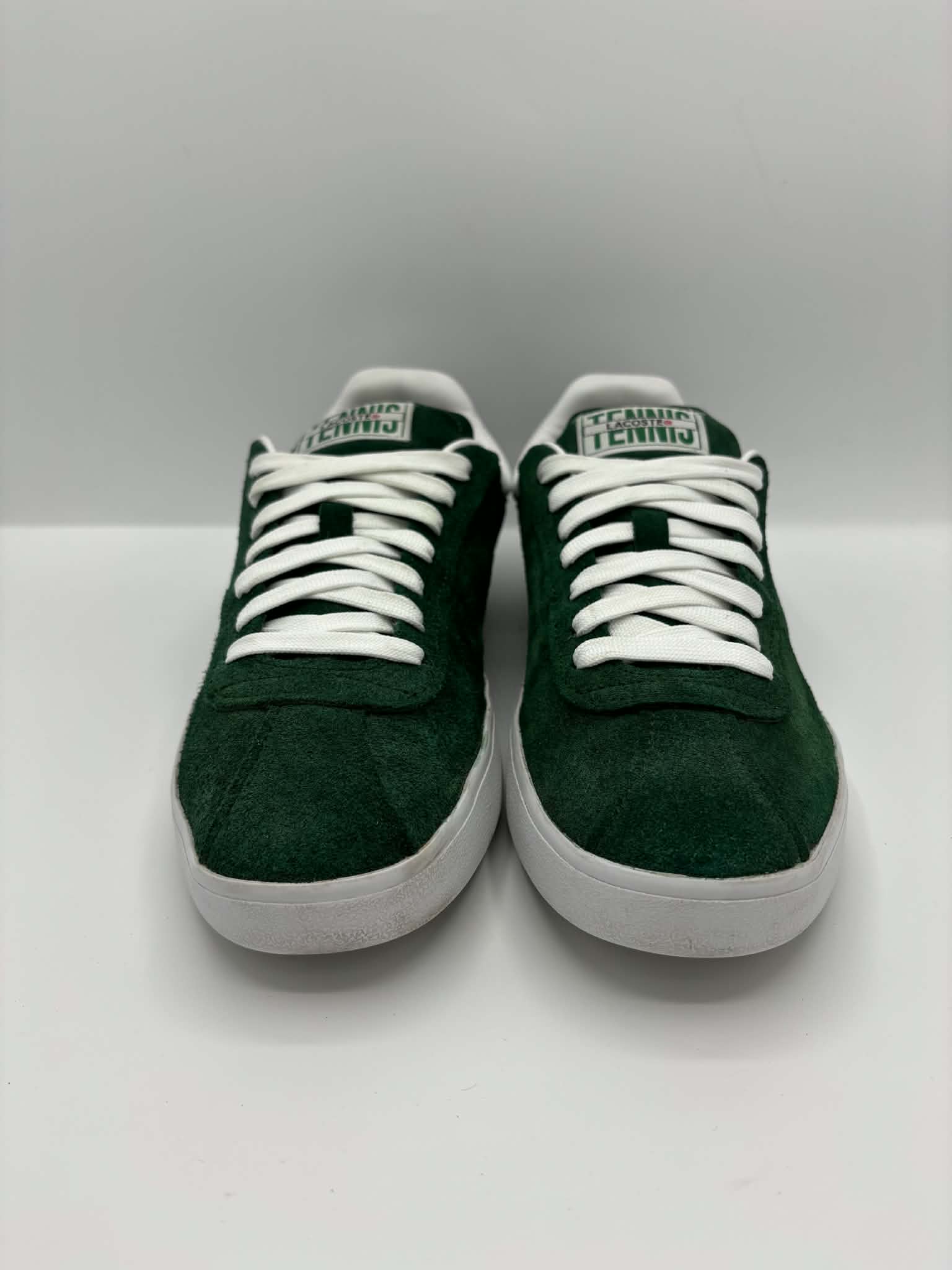 Même paire de sneakers Lacoste vertes après les soins, avec des lacets et des semelles nettoyés