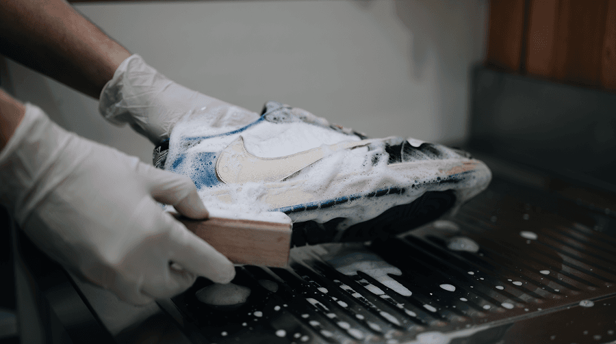 Nettoyage à la main d’une sneaker avec une brosse en atelier