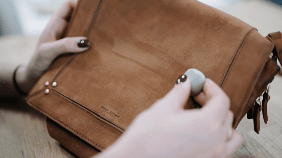 Soin à la main de la surface d’un sac en cuir camel