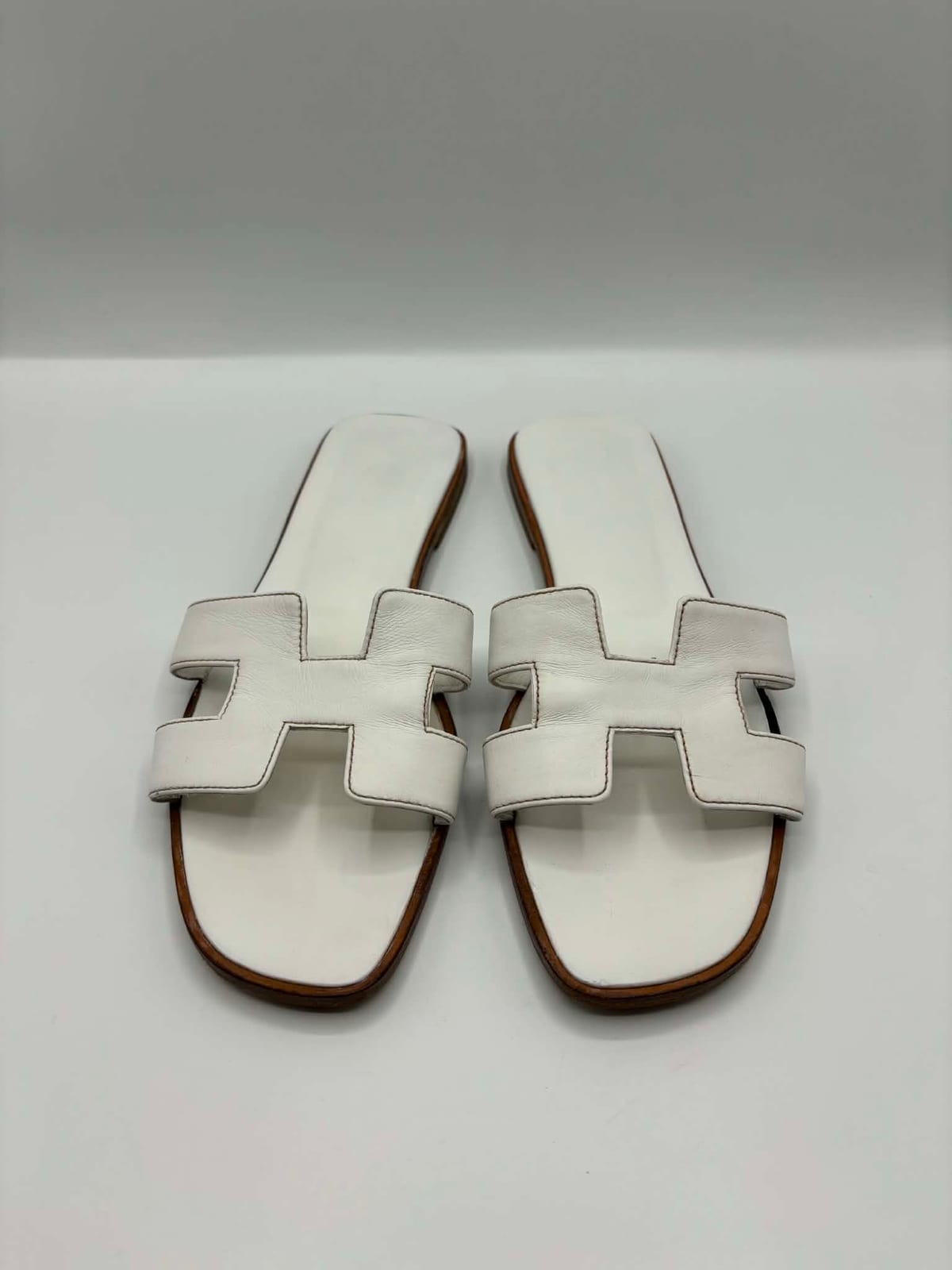 Sandales Hermès Oran blanches après les soins dans notre atelier