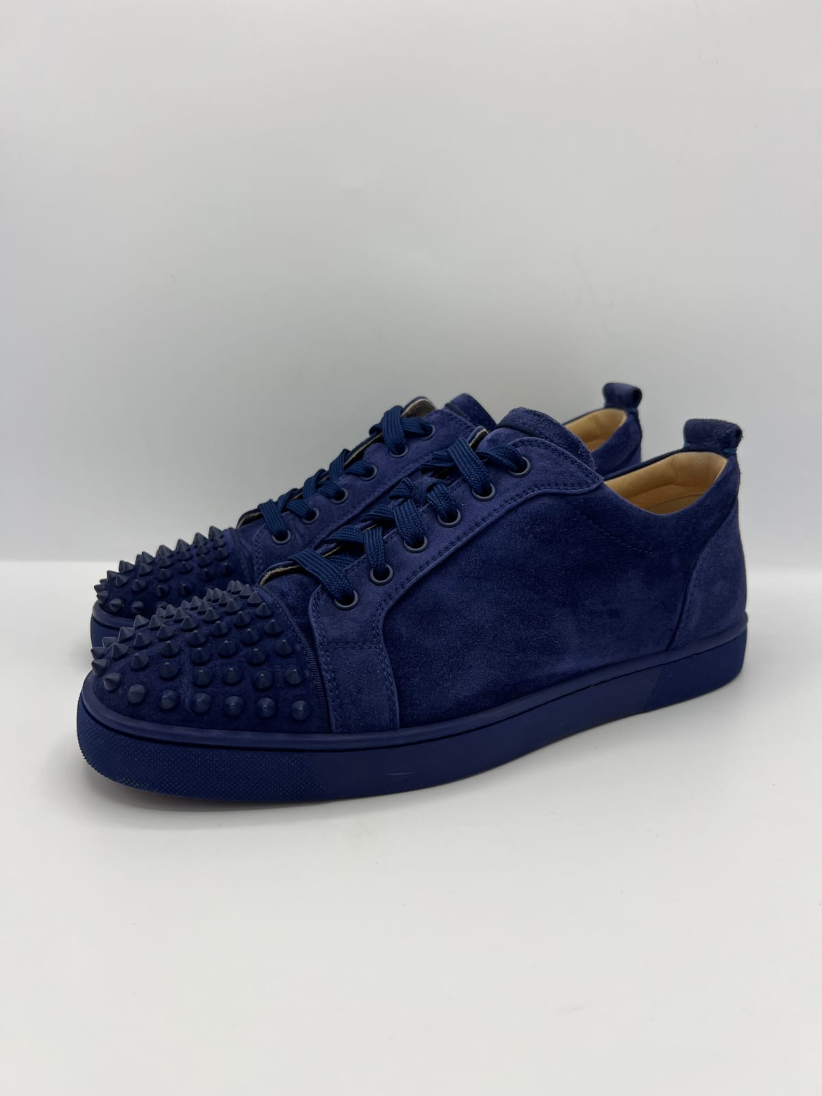 Sneakers Louboutin en daim bleu à clous après les soins dans notre atelier